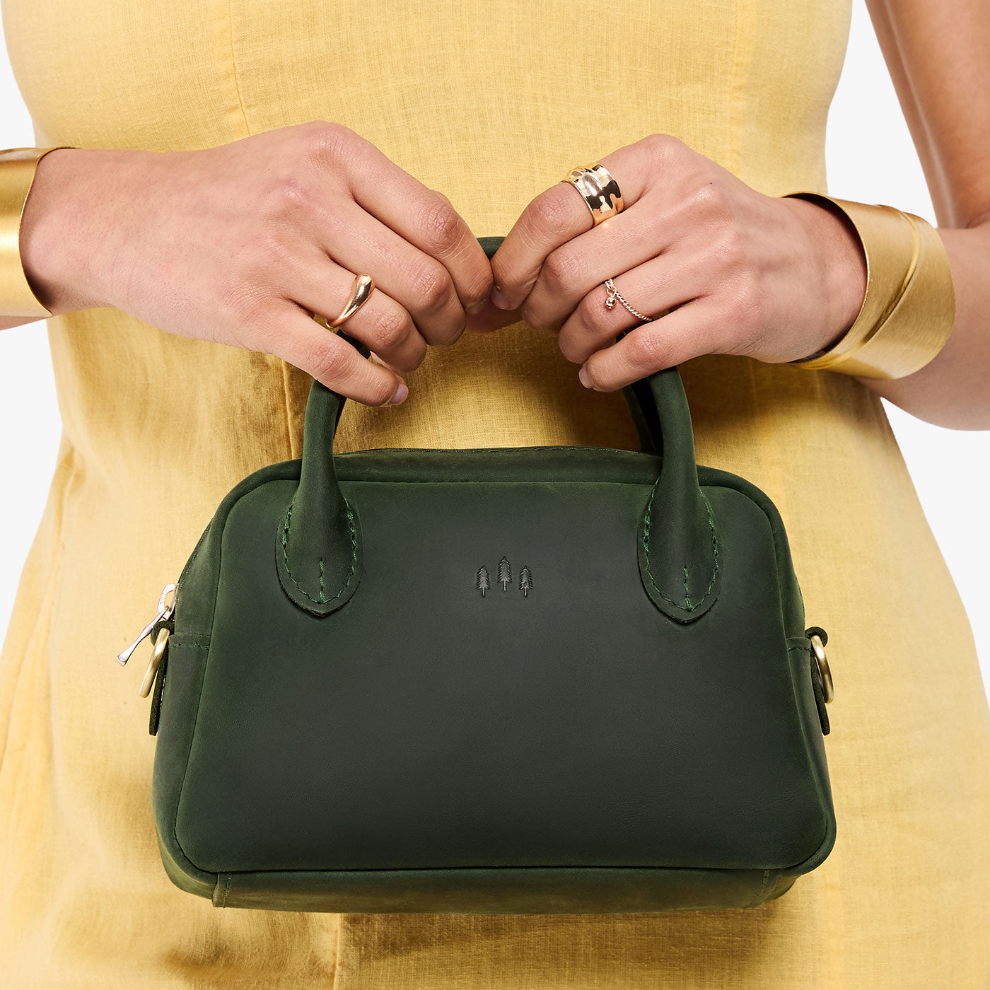 Evergreen*Small | A bowler styled bag being held by a model in a yellow dress