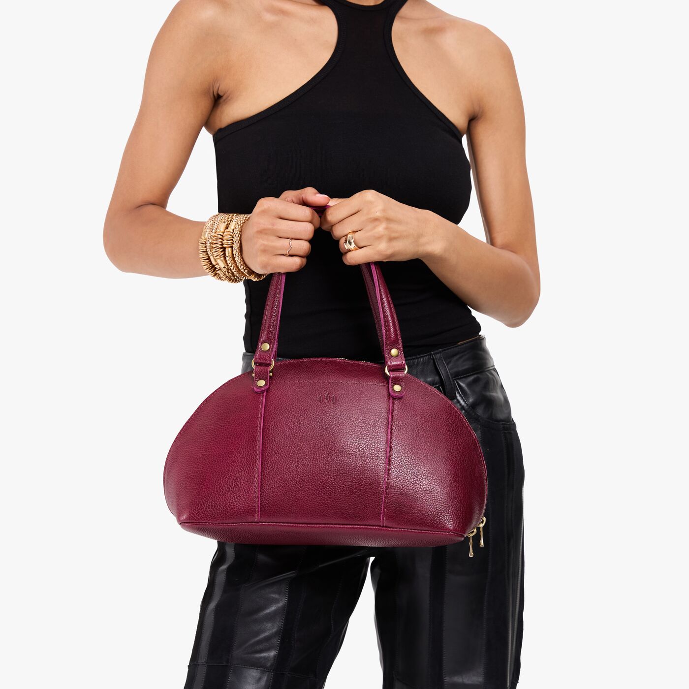 Orchid*Small | Model holding a half circle crossbody bag with handles and removable crossbody strap 