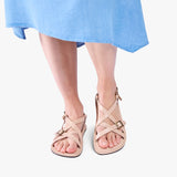 Crema | Person wearing strappy leather sandals with two buckle accents