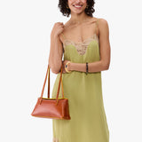 Sienna | Model wearing light green dress carrying leather bowler bag with magnetic closure