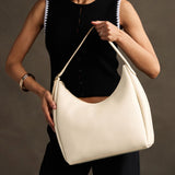 Pebbled Bone Large | U-shaped, flat-bottomed leather shoulder bag with adjustable strap