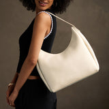 Pebbled Bone Large | U-shaped, flat-bottomed leather shoulder bag with adjustable strap