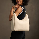 Pebbled Bone Large | U-shaped, flat-bottomed leather shoulder bag with adjustable strap