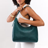 Sea Glass Large | Model holding u-shaped, flat-bottomed leather shoulder bag with adjustable strap