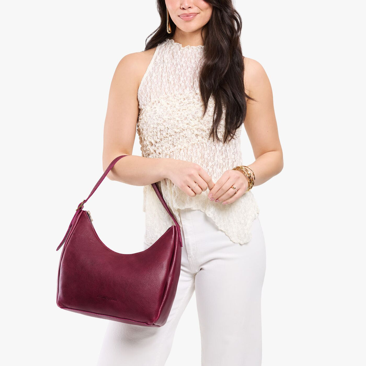 Orchid*Medium | Model holding u-shaped, flat-bottomed leather shoulder bag with adjustable strap
