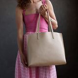 Jasmine | Model holding white tote bag with debossed floral design