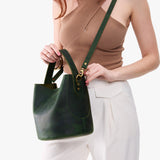 Evergreen Large | Model holding symmetrical bucket bag with handle, latch closure, and removable crossbody strap