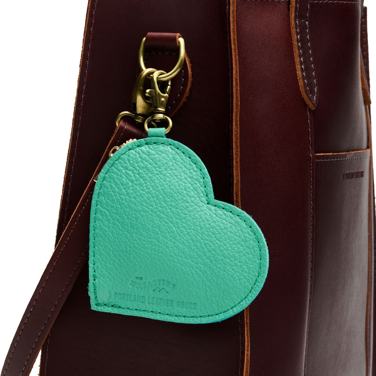 Spruce | Heart-shaped pouch with a gold clasp on a bag