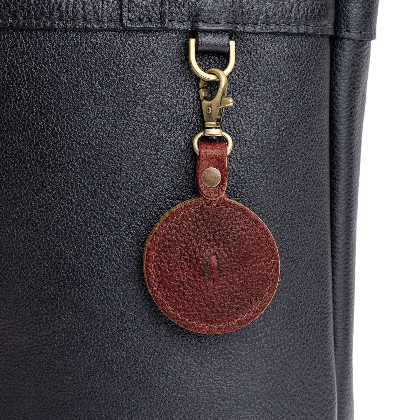 Nutmeg | Heart-shaped airtag holder keychain with a swivel lobster clasp on bag