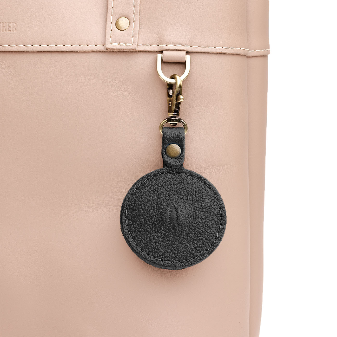 Pebbled--black | Circle-shaped airtag holder keychain with a swivel lobster clasp on bag