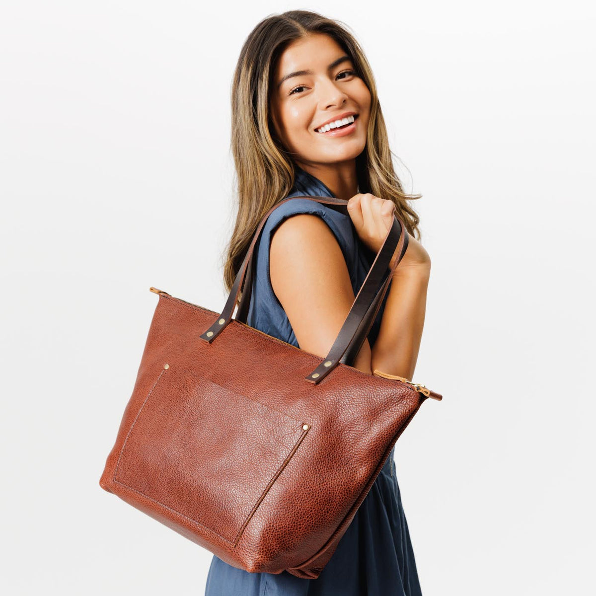 Nutmeg*Zipper  | Model holding large zipper leather tote bag with sturdy bridle handles and front pocket