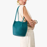 Aquarius Classic | Model wearing matching white shirt and skirt carrying petite bucket shaped tote bag with matching leather handles