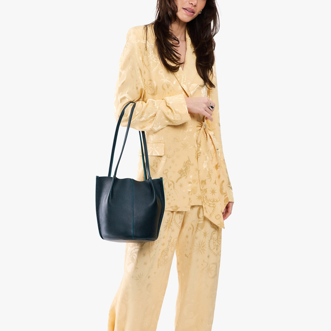 Boreal*Classic | Model wearing matching light yellow shirt and trousers carrying petite bucket shaped tote bag with matching leather handles