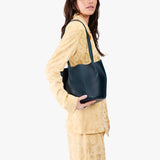 Boreal Classic | Model wearing matching light yellow shirt and trousers carrying petite bucket shaped tote bag with matching leather handles