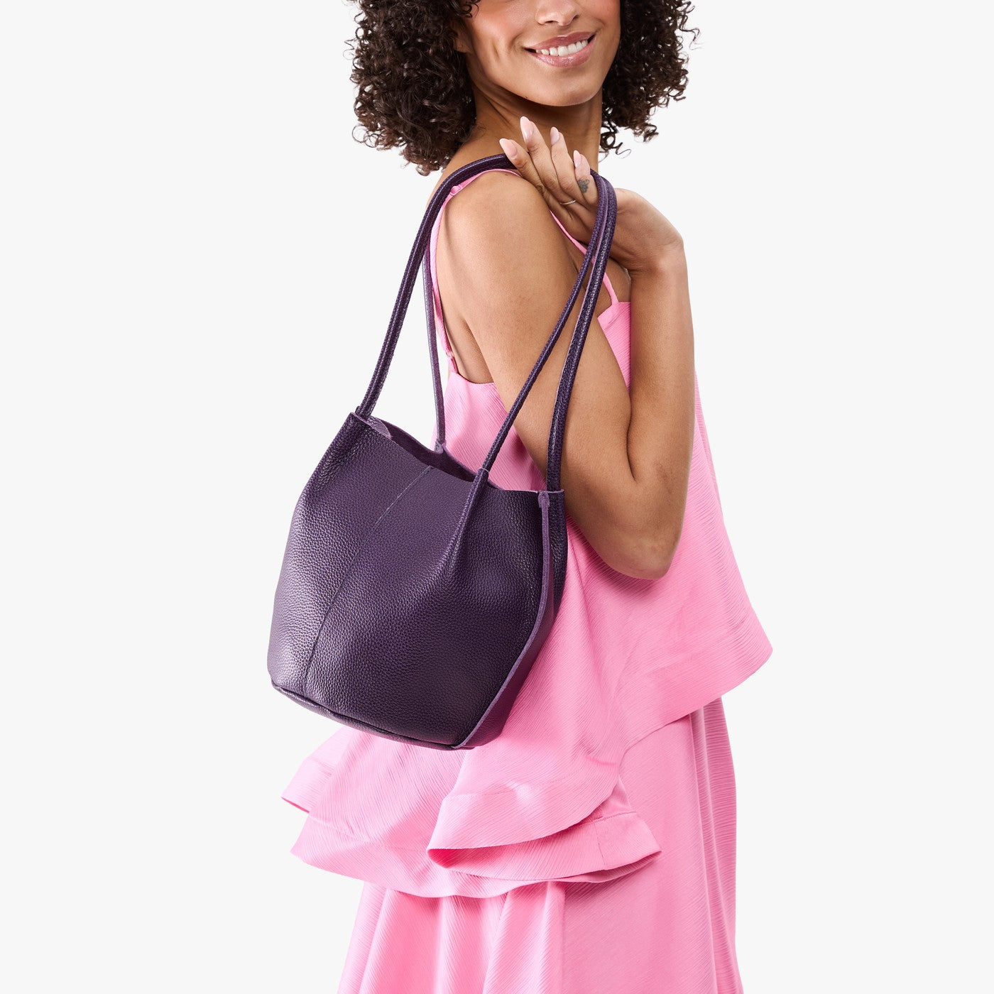 Empire*Classic | Model wearing sleeveless pink dress carrying petite bucket shaped tote bag with matching leather handles