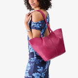 Cosmo Large | Model wearing blue floral patterned dress carrying wide bucket shaped tote bag with matching leather handles