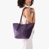 Empire Large | Model wearing white sleeveless shirt and matching pants carrying wide bucket shaped tote bag with matching leather handles