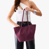 Superbloom Large | Model holding wide bucket shaped tote bag with matching leather handles