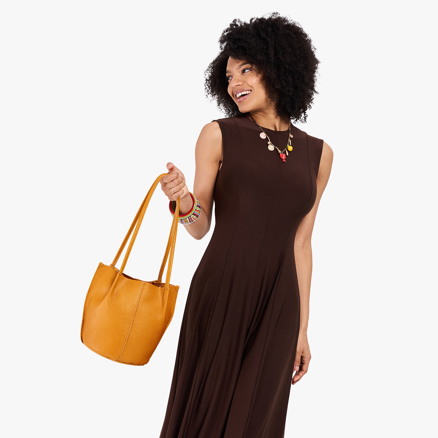 Sunshine*Classic | Model wearing dark brown dress holding petite bucket shaped tote bag with matching leather handles
