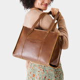 Asheville East/West | Model wearing structured wide tote bag with overlapping panels and crossbody strap