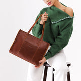 Nutmeg East/West | Model wearing structured wide tote bag with overlapping panels and crossbody strap