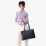 Night Owl Oversized East/West | Model holding structured wide tote bag with overlapping panels and crossbody strap