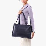 Night Owl Oversized East/West | Model holding structured wide tote bag with overlapping panels and crossbody strap