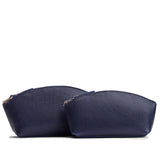 Cobalt | Comparison of two sizes of spacious leather makeup bags with curved seams and top zipper