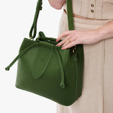 Cactus Large | Model holding symmetrical leather bag with leather drawstring closure and adjustable shoulder strap