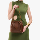 Asheville Small | Model holding symmetrical leather bag with leather drawstring closure and adjustable shoulder strap