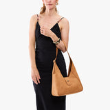 Desert Flower | Model carrying structured hobo shoulder bag with floral patterned embossed leather, adjustable strap and magnetic closure
