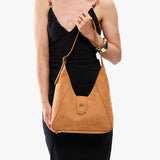 Desert Flower | Model carrying structured hobo shoulder bag with floral patterned embossed leather, adjustable strap and magnetic closure