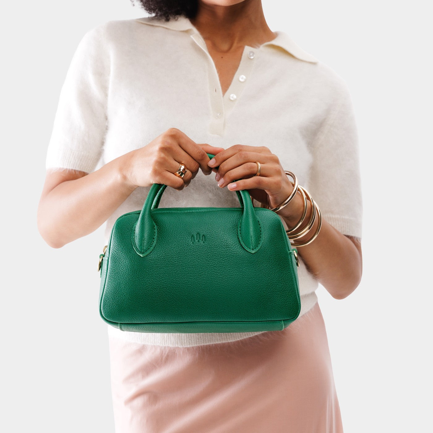 Bacalar*Large | A large bowler styled bag with a crossbody strap being held by a model in a white knit top