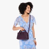 Larkspur Large | A large bowler styled bag with a crossbody strap being worn by a model in a light blue floral dress