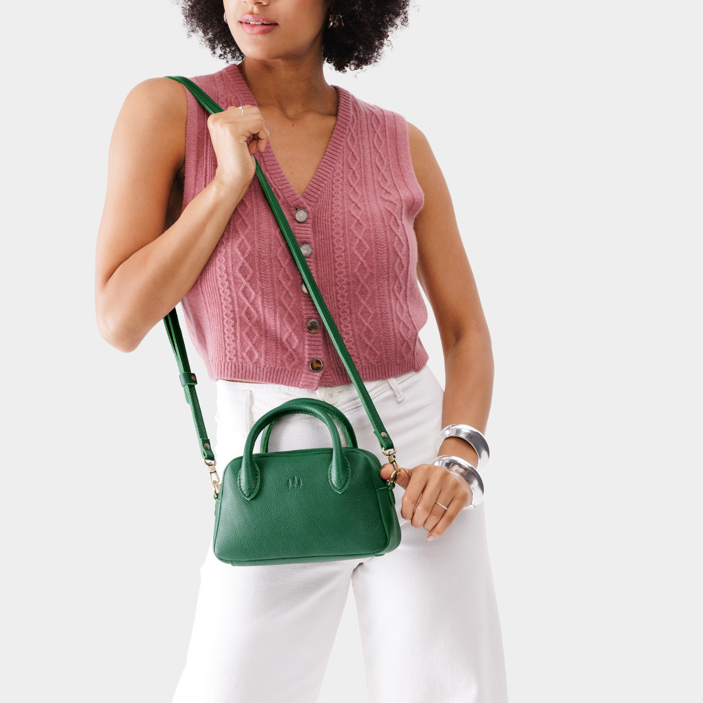 Bacalar*Small | A bowler styled bag with a crossbody strap being worn by a model wearing a pink knit vest