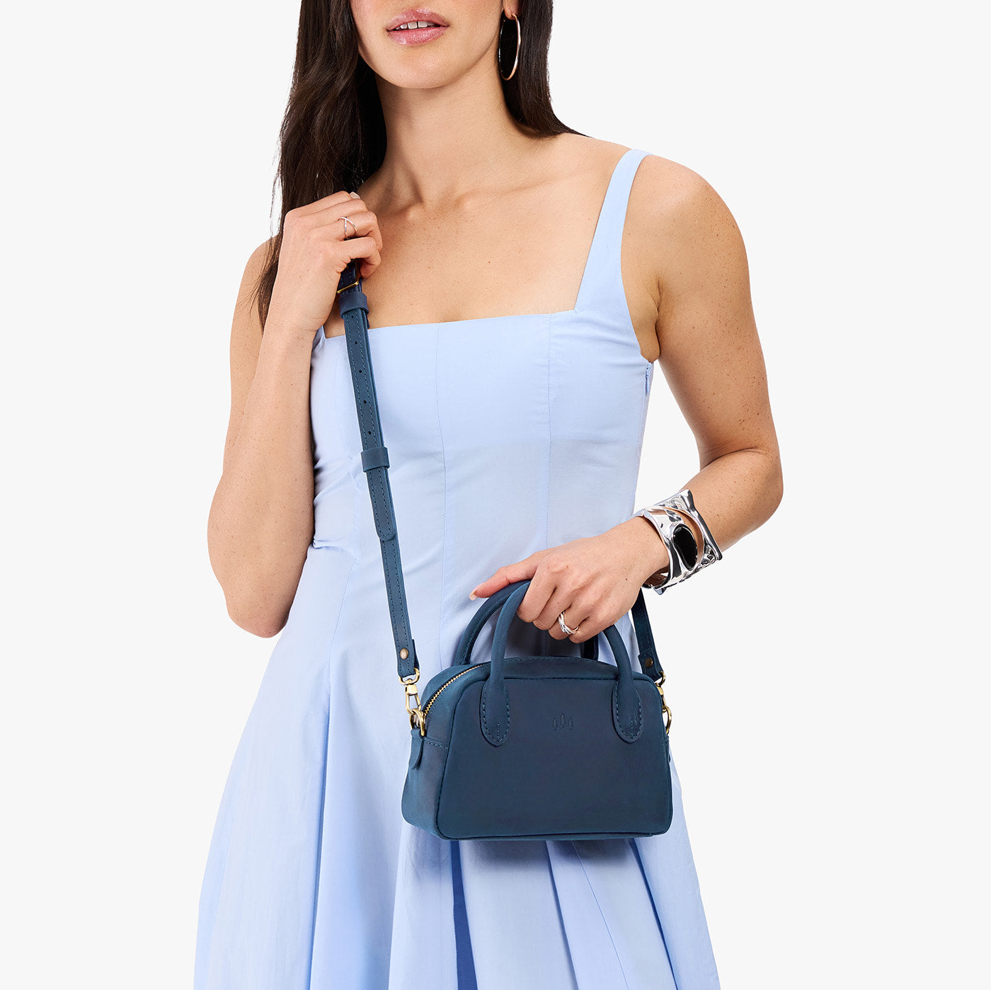 Deep Water*Small | A bowler styled bag with a crossbody strap being worn by a model in a light blue dress