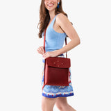 Phoenix | Model carrying slim satchel bag with crossbody strap and flap with magnet snap closure