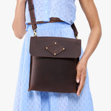 Moose | Model carrying slim satchel bag with crossbody strap and flap with magnet snap closure