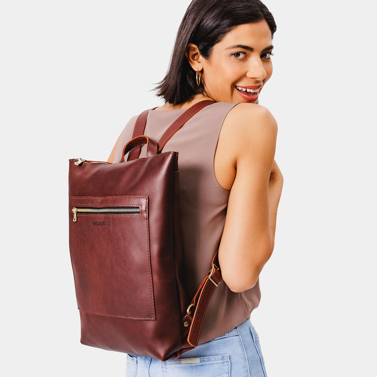 All Color: Cognac | Model wearing rectangular slim leather backpack
