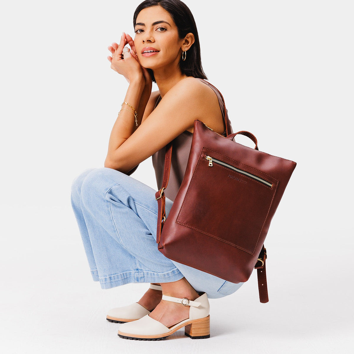 All Color: Cognac | Model wearing rectangular slim leather backpack