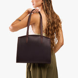 Moose Large | Model carrying leather tote bag with handles, adjustable crossbody strap, and two back pockets
