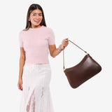 Chocolate Brown Large | Model holding a bean shaped shoulder bag with a zipper closure