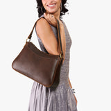 Coldbrew Large | Model holding a bean shaped shoulder bag with a zipper closure