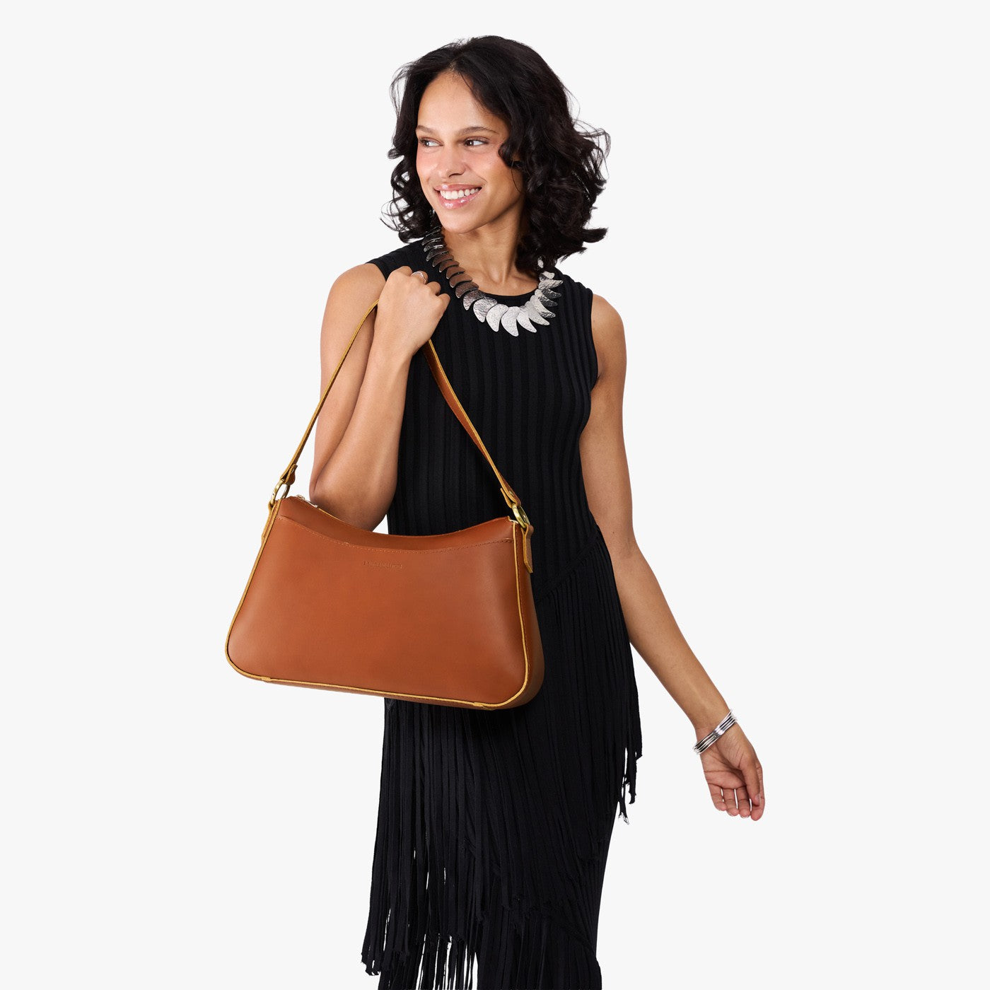 Honey*Large | Model holding a bean shaped shoulder bag with a zipper closure