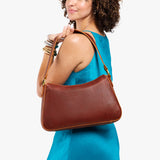 Nutmeg Large | Model holding a bean shaped shoulder bag with a zipper closure