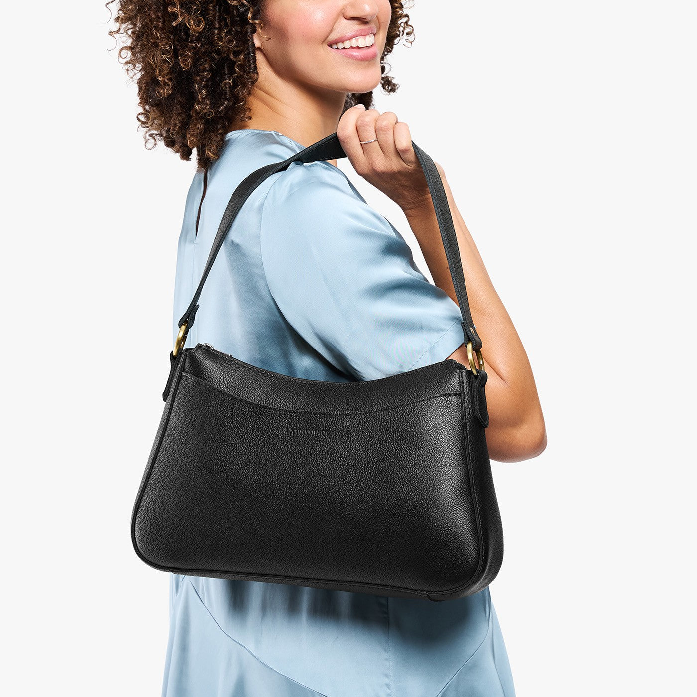 Pebbled--black*Large | Model holding a bean shaped shoulder bag with a zipper closure