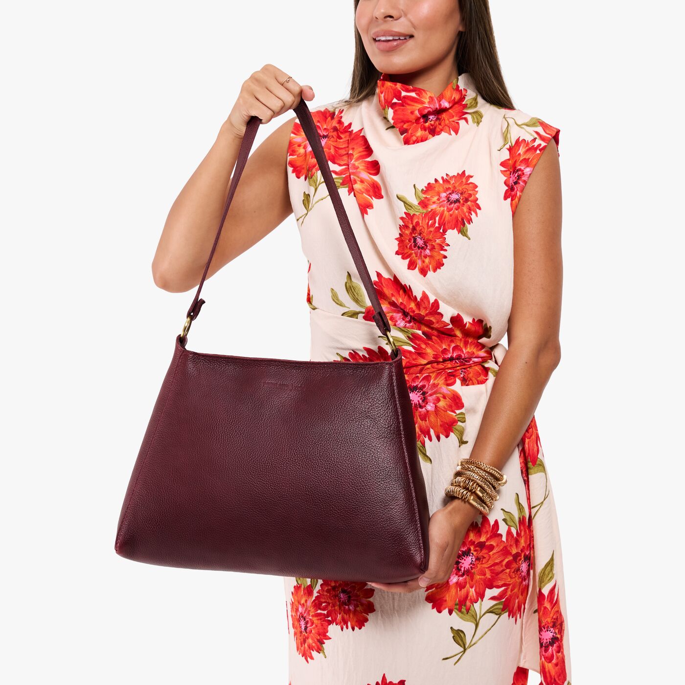 Cabernet*Large | Model holding a triangular shoulder bag with antiqued brass finished 