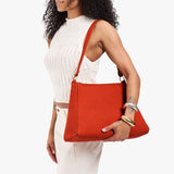 Paprika Large | Model holding a triangular shoulder bag with antiqued brass finished 