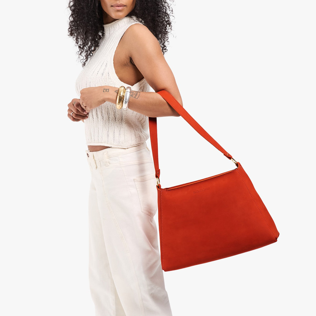 Paprika*Large | Model holding a triangular shoulder bag with antiqued brass finished 