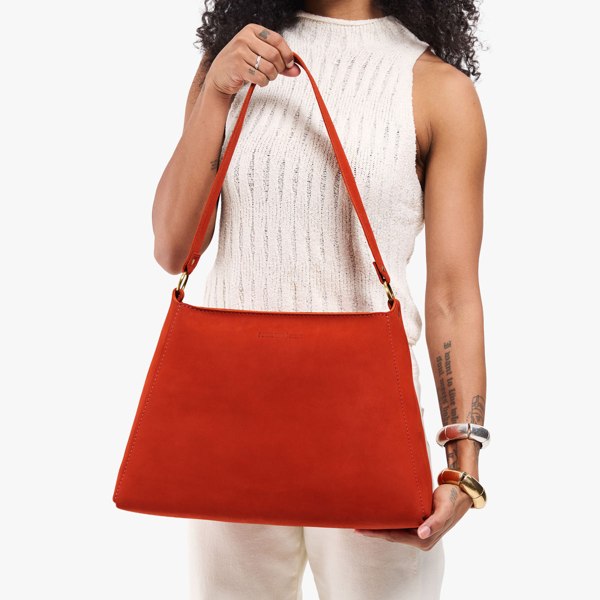 Paprika*Large | Model holding a triangular shoulder bag with antiqued brass finished 